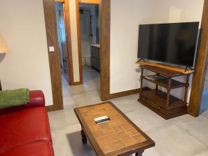 a living room with a television and a red couch at Magdalenea - Apartamento in Lesaka