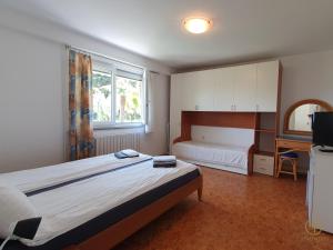 a bedroom with a bed and a desk and a television at Apartment with SeaView and Garden for 6 in Portorož