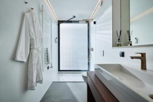 uma casa de banho branca com um lavatório e um espelho em Roodewoud em Rolde