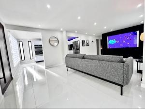 sala de estar con sofá y TV de pantalla plana en Five Minute Elegance New Spacious Home with Pool en Carolina