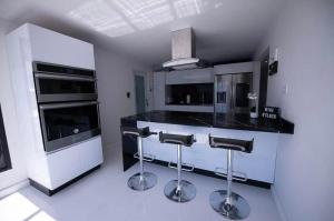 a kitchen with a black counter and stools in it at Five Minute Elegance New Spacious Home with Pool in Carolina