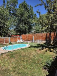 una piscina en un patio junto a una valla en Las Flores, casa del cerro en Potrerillos
