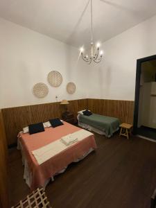 a bedroom with two beds and a chandelier at A la Gurda in San Miguel de Tucumán