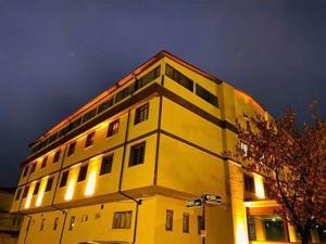 Animos Butik Otel في أنقرة: مبنى أصفر عليه أضواء