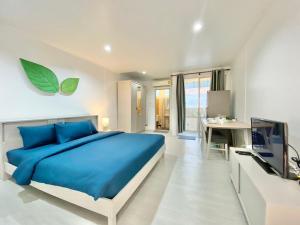a bedroom with a blue bed and a television at Chalong Interview Condominium - Chalong in Chalong 