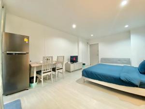 a bedroom with a bed and a desk and a table at Chalong Interview Condominium - Chalong in Chalong 