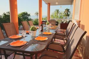 una mesa de madera con servilletas de naranja y sillas en el patio en TESS Villa Paradise, en Alhaurín de la Torre