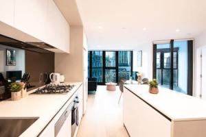 a kitchen with white counters and a stove top oven at Stunning 2BR Apt nr Yarra City view Free parking in Melbourne