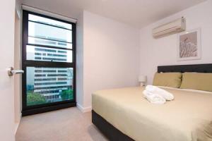 a bedroom with a large bed and a window at Stunning 2BR Apt nr Yarra City view Free parking in Melbourne