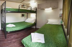 2 literas en una habitación con sábanas verdes en Firenze Certosa camping, en Impruneta