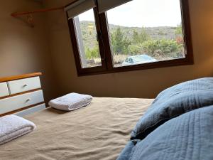 1 dormitorio con cama y ventana en RETAMA en San Carlos de Bariloche