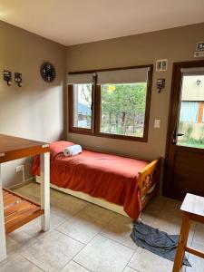 Habitación pequeña con cama y ventana en RETAMA en San Carlos de Bariloche