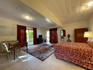 a bedroom with a bed and a desk and a table at Valle Dorado Sierra de los Padres in Sierra de los Padres