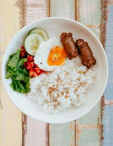 uma tigela de arroz com ovos, carne e legumes em San Juanico Travellers Inn - RedDoorz em Tacloban