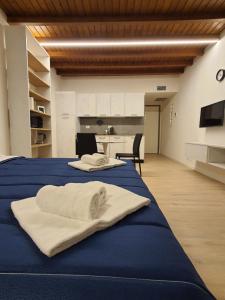 2 handdoeken op een blauw bed in een kamer bij RESIDENZA I PORTICI in Castelleone