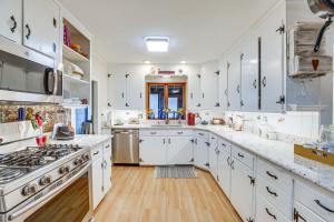 una cocina con armarios blancos y encimeras blancas en Pet-Friendly Franklinville Farmhouse with Sunroom!, 