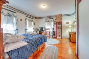 a bedroom with a bed with a blue comforter at Pet-Friendly Franklinville Farmhouse with Sunroom! 