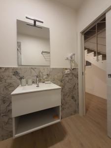 een badkamer met een witte wastafel en een spiegel bij RESIDENZA I PORTICI in Castelleone
