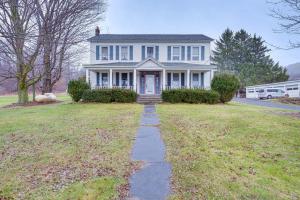 a white house with a sidewalk in front of it at Pet-Friendly Franklinville Farmhouse with Sunroom! 