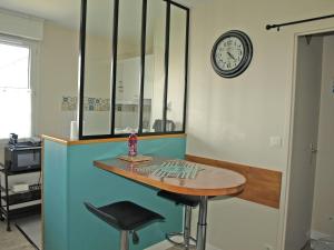 um quarto com uma mesa e um relógio na parede em a lovely nest em Bussy-Saint-Georges