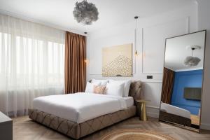 a bedroom with a large bed and a tv at Siesta Boutique Smart Suites in Cluj-Napoca