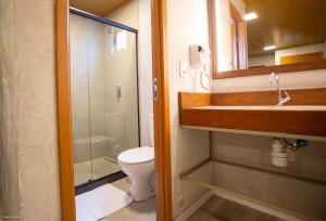 ein Badezimmer mit einem WC, einem Waschbecken und einem Spiegel in der Unterkunft Bella Rosa Noronha in Fernando de Noronha
