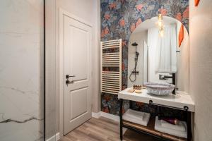 a bathroom with a sink and a mirror at Siesta Boutique Smart Suites in Cluj-Napoca
