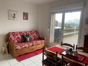 - un salon avec un canapé et une table dans l'établissement Appartement sur les hauteurs de Gérardmer, à Gérardmer