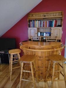 a bar with two stools and a book shelf at le familial avec spa, sauna salle de jeux in Xonrupt-Longemer