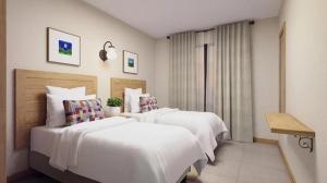 ein Hotelzimmer mit zwei Betten mit weißen Laken in der Unterkunft Hotel Quinta de Santa Bárbara Eco Resort in Pirenópolis