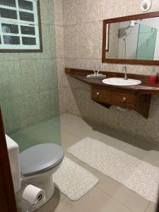 ein Badezimmer mit einem WC, einem Waschbecken und einem Spiegel in der Unterkunft Recanto do Peixe Dourado in Casimiro de Abreu