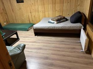a small room with two beds and a chair at Pirtis link Moletu in Vilnius
