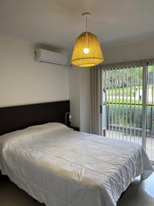 ein Schlafzimmer mit einem großen Bett und einem großen Fenster in der Unterkunft Departamento Veneto Village - D - in Villa Parque Siquiman