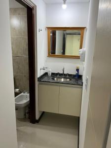 ein Badezimmer mit Waschbecken, Toilette und Spiegel in der Unterkunft Departamento Veneto Village - D - in Villa Parque Siquiman