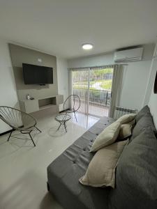 Schlafzimmer mit einem Bett, einem TV und Stühlen in der Unterkunft Departamento Veneto Village - D - in Villa Parque Siquiman