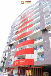 een groot appartementencomplex met rode en witte balkons bij Studio at Kisimani Heights Apartment. in Mombasa