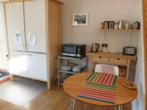 a small kitchen with a table and a microwave at The Bothy, Nethy Bridge in Nethy Bridge