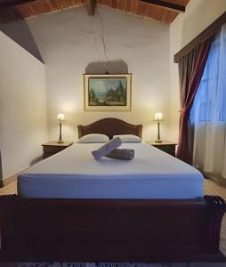 1 cama grande en una habitación con 2 lámparas en Casa Jardín Macondo en Medellín