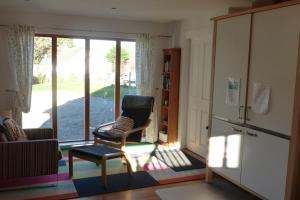 a living room with a chair and a sliding glass door at The Bothy, Nethy Bridge in Nethy Bridge