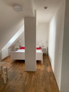 a white bedroom with two beds and a staircase at Mitte Apartments in Brno