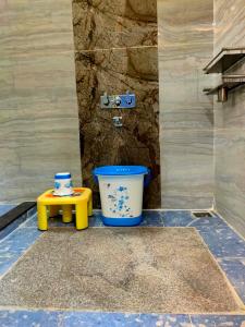 a bathroom with a bucket and a stool at Little Dream Homestay Hampi in Hampi