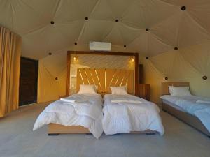 a bedroom with two beds in a tent at Salman Zwaidh Camp in Wadi Rum