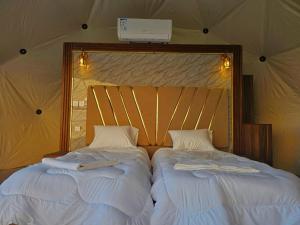 2 letti posti uno accanto all'altro in una camera da letto di Salman Zwaidh Camp a Wadi Rum