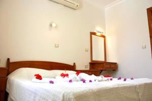 a bedroom with two beds with red flowers on them at Toloman Bitezpark Apartments in Bodrum City