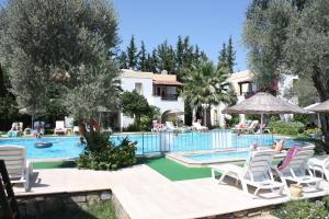 a villa with a swimming pool and a resort at Toloman Bitezpark Apartments in Bodrum City