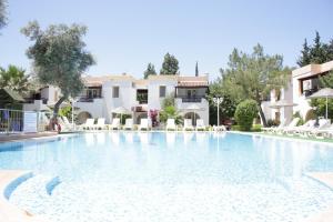 a large swimming pool in front of a villa at Toloman Bitezpark Apartments in Bodrum City
