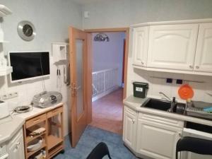 eine Küche mit weißen Schränken und einem Waschbecken in der Unterkunft Ferienhaus Residenz Wismar - ABC430 in Wismar