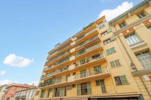 a tall yellow building with windows and balconies at NICE RENTING - PHILIBERT - Elegant Spacious Quiet Near the Port Free Parking in Nice