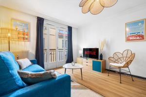 a living room with a blue couch and a tv at NICE RENTING - PHILIBERT - Elegant Spacious Quiet Near the Port Free Parking in Nice