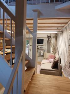 a living room with a couch and a staircase at Ferienhaus Nr 2 - Das kleine Haus im Haus in Heiligenstadt